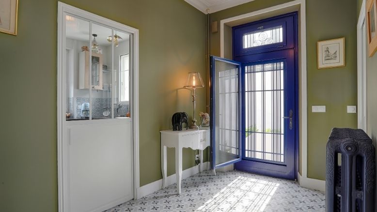 vue intérieur d'une maison avec une porte d'entrée sur mesure en bois avec chassis ovurant